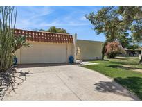 Charming home with a stucco wall, tile roof, paved driveway, and desert landscaping at 6147 E Lewis Ave, Scottsdale, AZ 85257