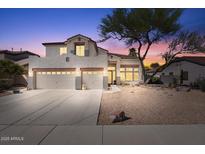 Charming two-story home with a desert landscape and a three-car garage, set against a colorful sunset sky at 838 E Nolan Pl, Chandler, AZ 85249