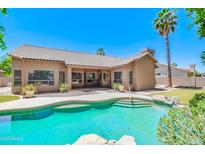 Inviting backyard pool with lush landscaping, rock features, and view of house and patio at 1470 W Bartlett Way, Chandler, AZ 85248