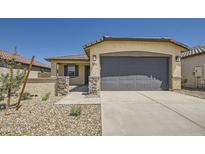 Charming single-story home featuring a stone-accented facade, two-car garage and low maintenance landscaping at 16762 W Alameda Rd, Surprise, AZ 85387