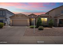 Charming single-story home with a well-manicured front yard and a two-car garage under a beautiful colorful sunset sky at 2177 W Agrarian Hills Dr, San Tan Valley, AZ 85144