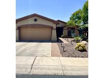 Charming single-story home featuring a two-car garage and desert landscaping with mature trees at 2461 W Muirfield Dr, Anthem, AZ 85086