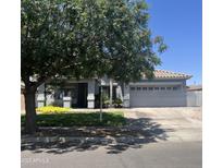 Charming single-Gathering home with lush green lawn and mature tree in front yard at 4140 E Claxton Ave, Gilbert, AZ 85297