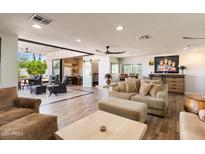 Open-concept living room featuring tile floors, neutral tones, plush seating, and access to the outdoor patio at 7510 E Larkspur Dr, Scottsdale, AZ 85260