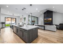 A modern open concept kitchen with a large island and stainless steel appliances with a view to the living room at 7851 N Central Ave, Phoenix, AZ 85020