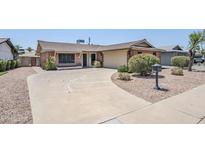 Charming single-story brick home with a large driveway and well-maintained landscaping at 8713 E Sage Dr, Scottsdale, AZ 85250