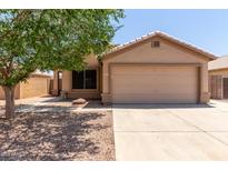Charming single-story home featuring a two-car garage, landscaped yard and mature shade tree on a sunny day at 9243 W Brown St, Peoria, AZ 85345