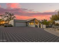 Beautiful home featuring neutral tones, a spacious driveway, desert landscaping, and a charming covered porch at 9432 E Quail Trl, Carefree, AZ 85377