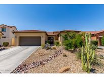 Charming single-story home features a desert-landscaped front yard with gravel and native plants at 17891 W Badger Way, Goodyear, AZ 85338