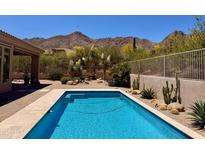 Backyard swimming pool surrounded by desert landscaping and mountain views at 23516 N 119Th Way, Scottsdale, AZ 85255