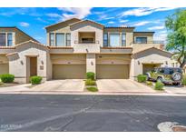 Charming townhome exterior with private garages and well-manicured landscaping under a sunny blue sky at 3131 E Legacy Dr # 1032, Phoenix, AZ 85042
