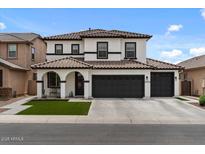 Beautiful two-story home featuring a three-car garage, neutral stucco, and a terra cotta colored tile roof at 3523 E Alfalfa Dr, Gilbert, AZ 85298