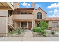 Inviting two-story condo with desert landscaping, a private balcony, and an attractive front door at 4901 E Kelton Ln # 1270, Scottsdale, AZ 85254