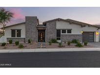 Charming single-story home showcasing stone accents, desert landscaping, and a two-car garage at 5218 N Tiller Dr, Litchfield Park, AZ 85340