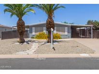 Charming single-story home featuring desert landscaping and mature palm trees, creating inviting curb appeal at 5436 E Aspen E Ave, Mesa, AZ 85206