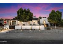 Charming home with modern landscaping, decorative wall, and trees providing curb appeal at 5707 N 12Th Pl, Phoenix, AZ 85014