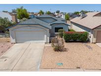 Charming single-story home with a two-car garage and low maintenance desert landscaping in front yard at 6938 W Nicolet Ave, Glendale, AZ 85303