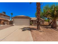 Charming single-story home featuring a well-maintained lawn, mature trees, and a two-car garage at 7426 W Cholla St, Peoria, AZ 85345