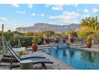 Lounge by the refreshing pool with water features and desert mountain views, perfect for relaxation at 7846 E Wilderness Trl, Gold Canyon, AZ 85118