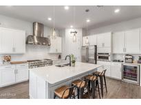 Bright kitchen with white cabinets, quartz island with seating, and stainless steel appliances at 9764 E Thornbush Ave, Mesa, AZ 85212