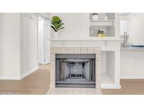 Cozy fireplace with white tile surround and wood flooring, perfect for a relaxing ambiance at 1126 W Elliot Rd # 2023, Chandler, AZ 85224