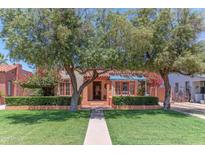 Charming front yard featuring lush green grass, mature trees and a well-maintained landscape at 1134 W Portland St, Phoenix, AZ 85007