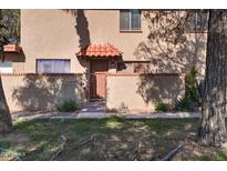 Inviting front entrance with a red tile awning, decorative wrought iron gate, and lush desert landscaping at 14404 N Boxwood Ln, Fountain Hills, AZ 85268