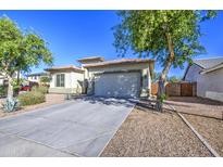 Charming single-story home featuring a two-car garage and desert landscaping under a clear, sunny sky at 25659 W Forest Grove Ave, Buckeye, AZ 85326