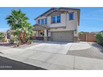 Two-story home boasts a neutral color palette, palm trees, large driveway, and attached two-car garage at 41143 W Rio Bravo Dr, Maricopa, AZ 85138