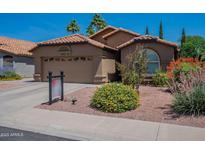 Charming single-story home featuring a tile roof and meticulously landscaped front yard at 5952 E Phelps Rd, Scottsdale, AZ 85254