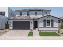 Charming two-story home featuring a gray tiled roof, brick driveway, and a neatly manicured lawn at 7944 W Griswold Rd, Peoria, AZ 85345