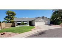 Charming one-story home with a well-maintained lawn, attached garage, and inviting curb appeal at 949 N Ricardo N Cir, Mesa, AZ 85205