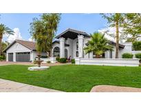 Stunning two-story home featuring lush landscaping, a decorative fountain, and a charming architectural design at 10662 E Carol Ave, Scottsdale, AZ 85258