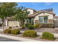 Charming single-Gathering home boasts well-maintained landscaping and a two-car garage, enhanced by solar panels on the roof at 10718 E Vivid Ave, Mesa, AZ 85212