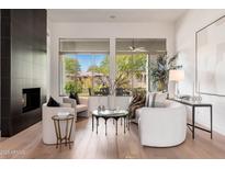 Bright living room with modern fireplace, white walls, and large windows with neighborhood view at 12366 N 129Th St, Scottsdale, AZ 85259