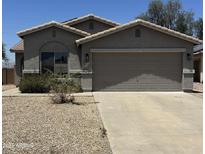 Charming single-story home with a two-car garage and low maintenance desert landscaping at 14038 N 162Nd Ln, Surprise, AZ 85379