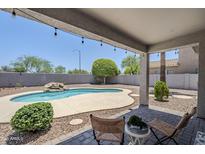 Relaxing outdoor patio with a private pool, desert landscaping, and charming string lights for evening ambiance at 2135 S Bristol --, Mesa, AZ 85209