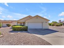 Well-maintained home with a two-car garage and low maintenance landscaping with desert rock and manicured bushes at 22609 S 214Th Way, Queen Creek, AZ 85142