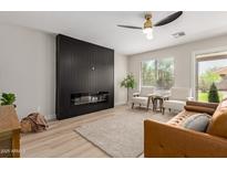 Bright living room with a modern fireplace, neutral color palette, ceiling fan, and comfortable seating at 33287 N Windmill Run, San Tan Valley, AZ 85144