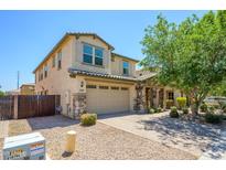 Charming two-story home with tan stucco, a tile roof, stone accents, and a large two car garage at 3361 E Wisteria Pl, Chandler, AZ 85286