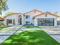 Beautiful modern home with a well-manicured front yard and a spacious glass garage door at 4748 E Redfield Rd, Phoenix, AZ 85032