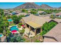 An inviting backyard featuring a sparkling pool, covered patio, and lush landscaping in a desert community at 4935 W Lariat Ln, Phoenix, AZ 85083