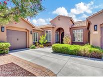 Charming stucco home featuring a tile roof, arched entry, manicured landscaping, and a spacious driveway at 4935 W Lariat Ln, Phoenix, AZ 85083