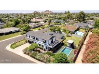 Aerial view of the property showcasing the home's backyard pool, mountain views and surrounding neighborhood at 6196 E Calle Camelia --, Scottsdale, AZ 85251