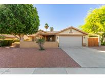 Inviting single-story home with a well-maintained yard, covered porch and mature trees offering great curb appeal at 6430 E Riverdale St, Mesa, AZ 85215