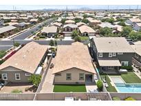 An aerial view shows a neighborhood with well-maintained homes, green lawns and a community pool at 7440 E Osage Ave, Mesa, AZ 85212