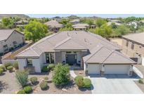 Beautiful single-story home features a tile roof, stone accents, manicured landscaping, and a three-car garage at 9225 W Bajada Rd, Peoria, AZ 85383