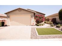 Charming single-story home with a well-manicured lawn, brick driveway, and blooming tree at 1364 W Spine Tree Ave, Queen Creek, AZ 85140