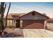 Charming single-story home with a well-maintained front yard, complemented by desert landscaping and a two car garage at 13862 W Fargo Dr, Surprise, AZ 85374