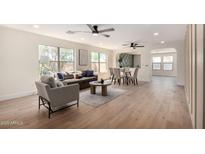 Bright, open-concept living room and dining room with light wood floors and abundant natural light at 13862 W Fargo Dr, Surprise, AZ 85374